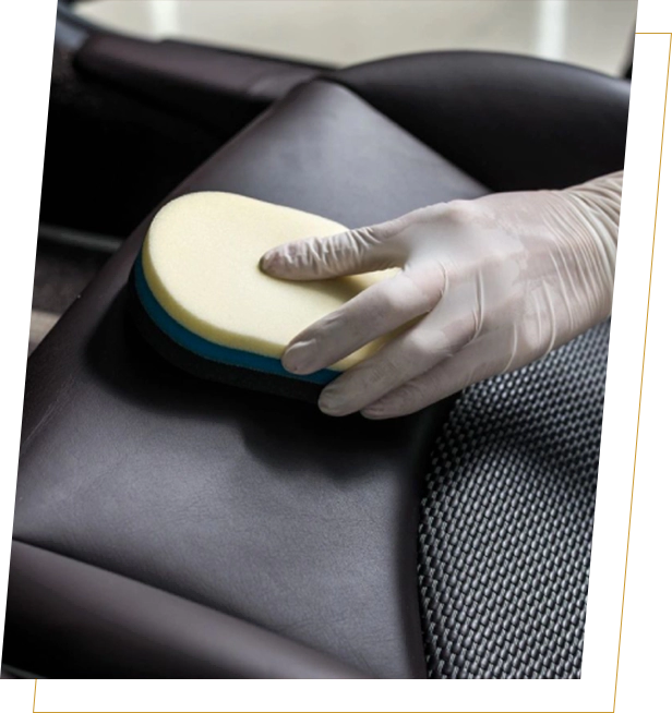 A person is cleaning the seat of an automobile.