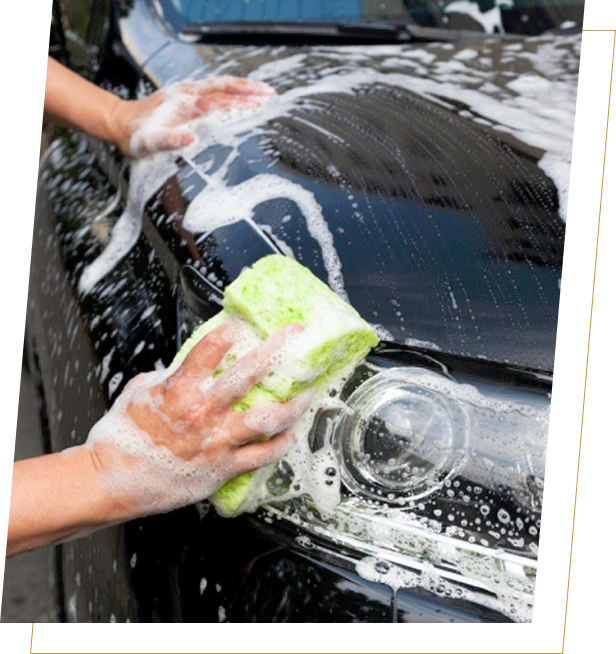 A person washing their car with soap and water.