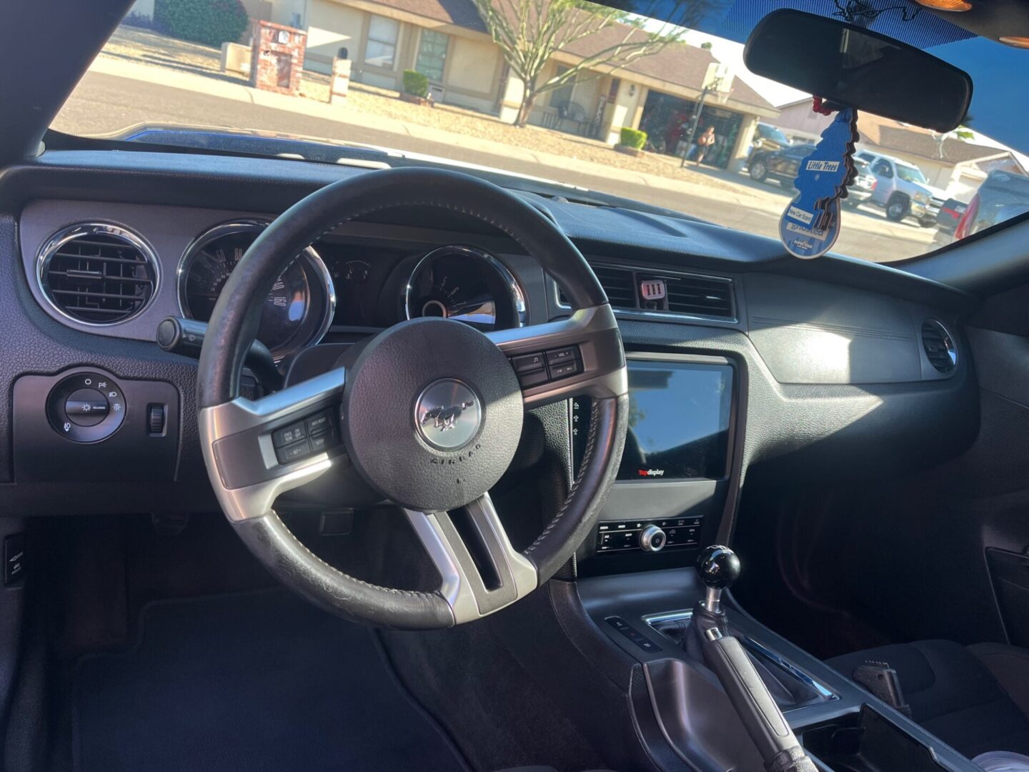 A car is shown with the dashboard and steering wheel.