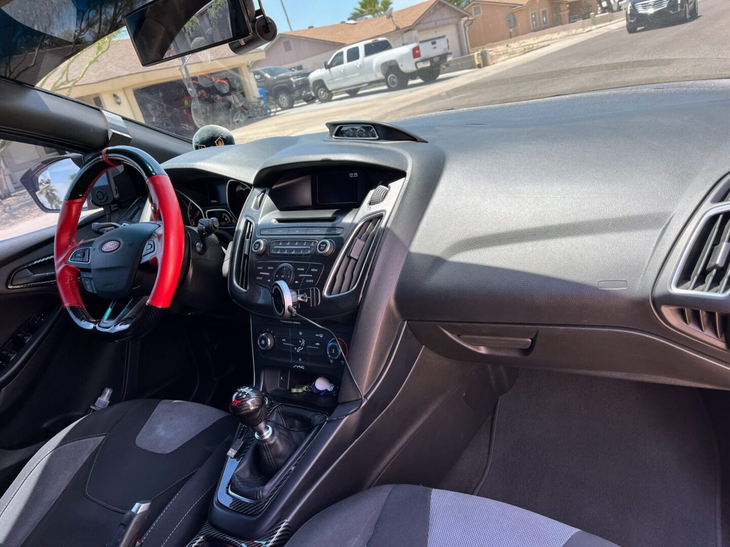 A car dashboard with the steering wheel and dash.